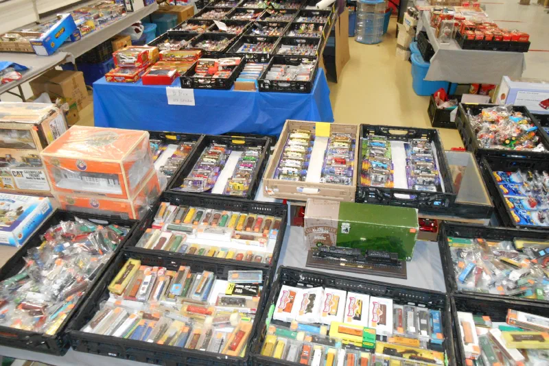 Vendor tables of boxed collectibles laid out at the market
