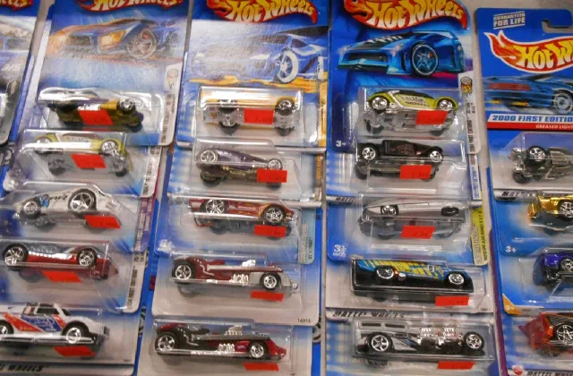 Carded Hot Wheels and die-cast cars laid out in rows